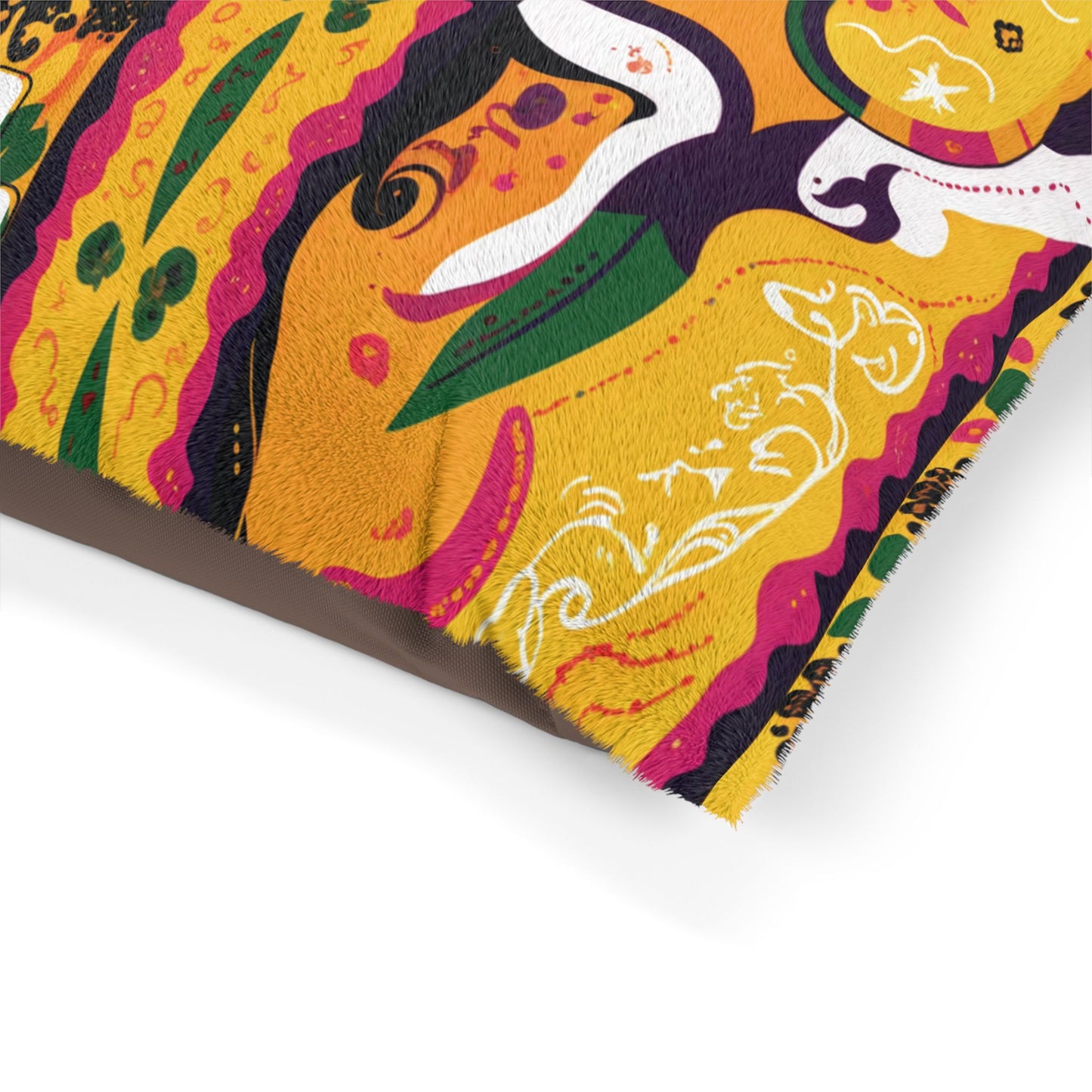 Close-up of a vibrant, colorful pillow corner featuring swirling, African-inspired patterns in yellow, orange, green, black, and white. The soft fabric displays intricate decorative designs and stylized plant shapes with detailed, whimsical artwork.