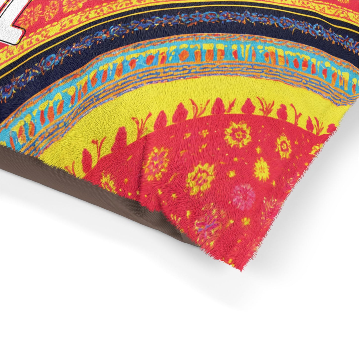 Close-up of a colorful, African-inspired woven fabric with intricate patterns in red, yellow, blue, and black. The design features rows of geometric shapes, floral motifs, and stylized outlines of people. The fabric’s edge is slightly frayed, revealing its texture.