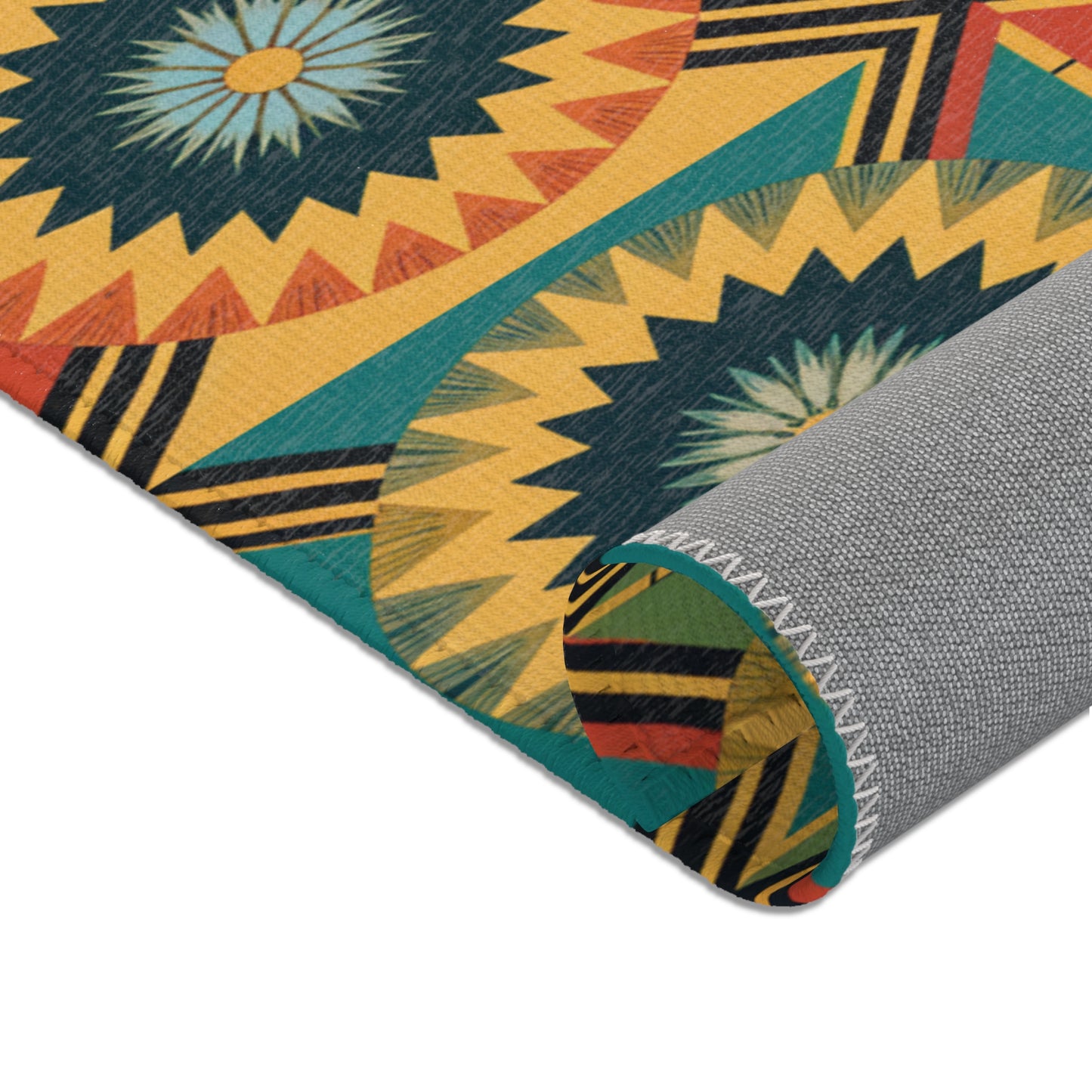 A colorful patterned rug corner is rolled up, revealing a gray woven backing with white zigzag stitching. The front features bold geometric starburst designs inspired by African design rugs in yellow, teal, orange, and black on a mustard background.