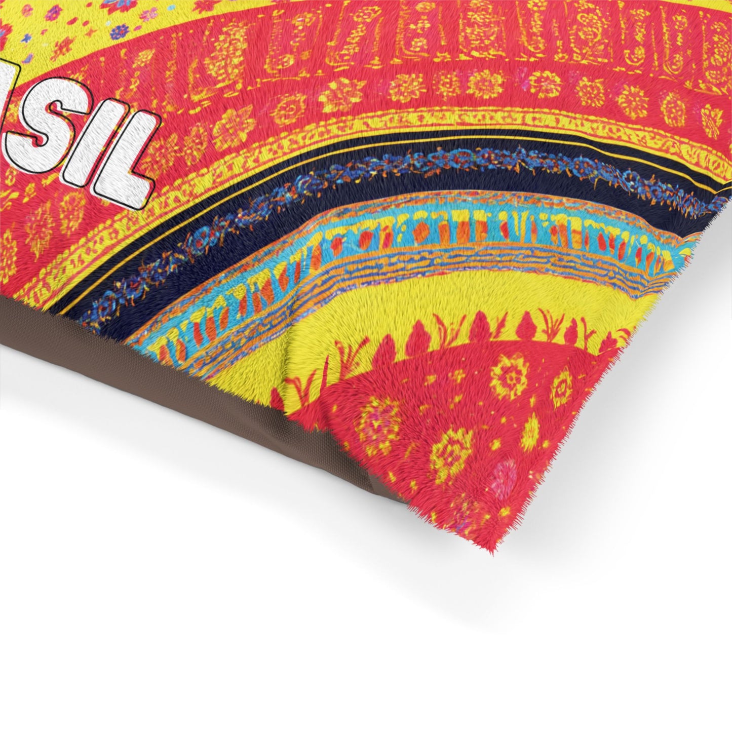 Close-up of a colorful, African-inspired fabric with intricate yellow, red, blue, and orange patterns. The partial word “SIL” appears in bold white letters on the left, and a frayed edge is visible at the bottom right corner.