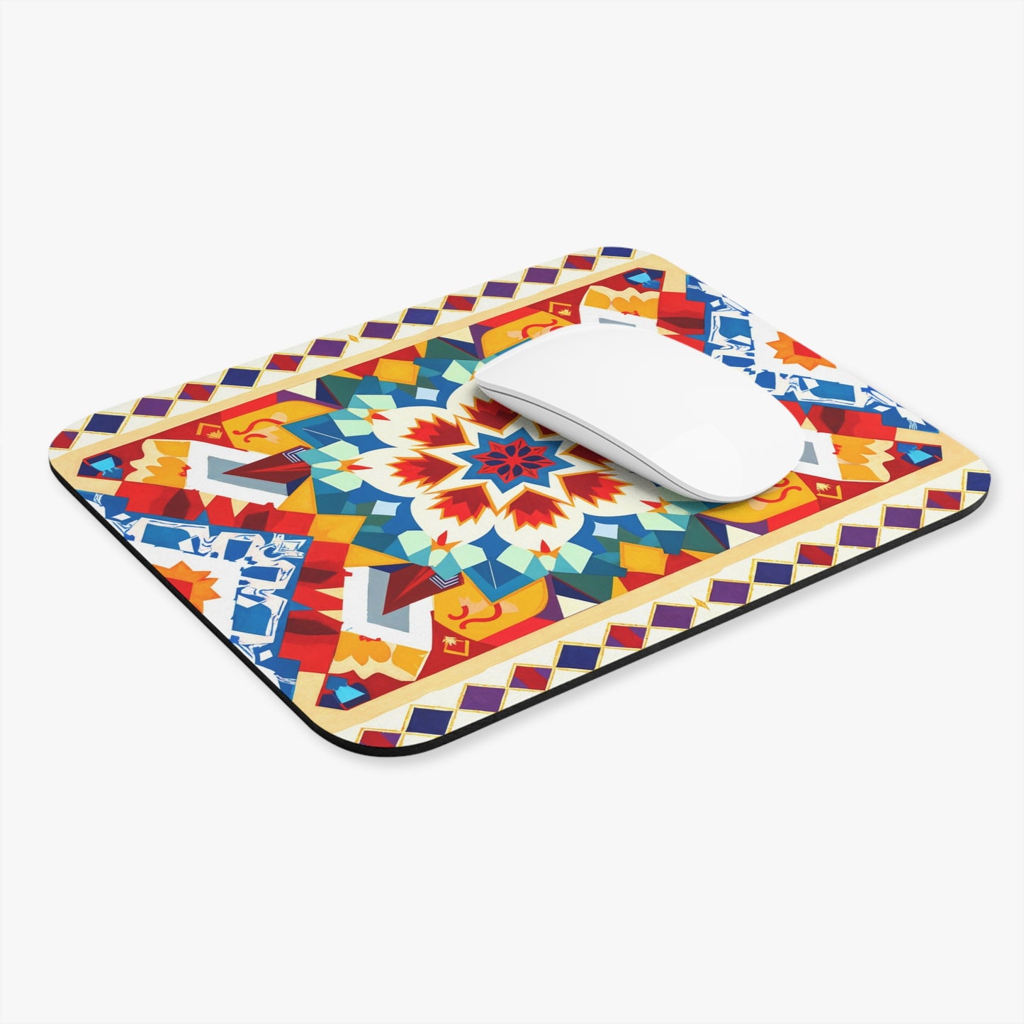A rectangular African-inspired mouse pad featuring a colorful geometric pattern with a central starburst motif in red, blue, yellow, and orange hues. This vibrant desk accessory includes a non-slip rubber base and is shown with a white wireless mouse on top.