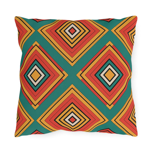 Square outdoor pillow with a colorful geometric pattern of concentric diamond shapes in red, orange, yellow, black, and white on a teal background. Made from weatherproof materials with a customizable design that repeats symmetrically.