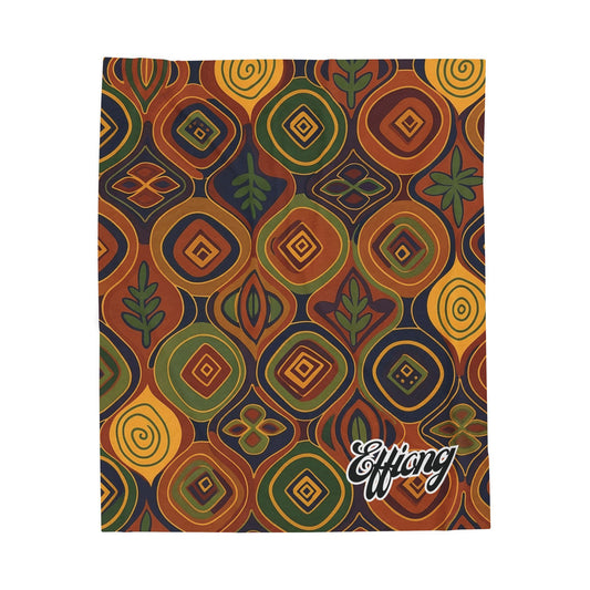 Rectangular cloth with a bold, colorful geometric and floral pattern in orange, yellow, green, and brown. This African-inspired blanket features concentric diamonds and stylized plant motifs. The bottom right corner has the white cursive text Efflang.