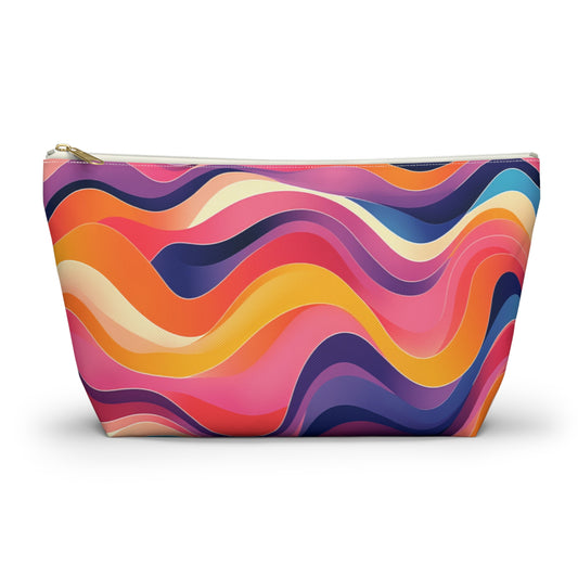 A vibrant cosmetic travel bag with a wavy, African-inspired pattern in pink, orange, yellow, purple, and dark blue. The contour-like lines create a lively abstract design. This T-bottom pouch stands upright with a gold zipper at the top.