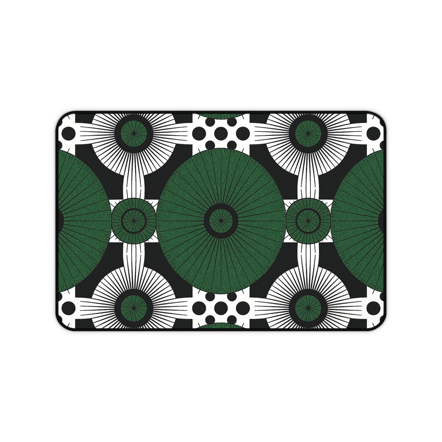 Rectangular neoprene desk mat with a bold geometric pattern: large green circles radiate in a grid, surrounded by smaller black and white circles, sunburst shapes, and black dots on black. A clean, modern colorful workspace accessory with symmetrical design.