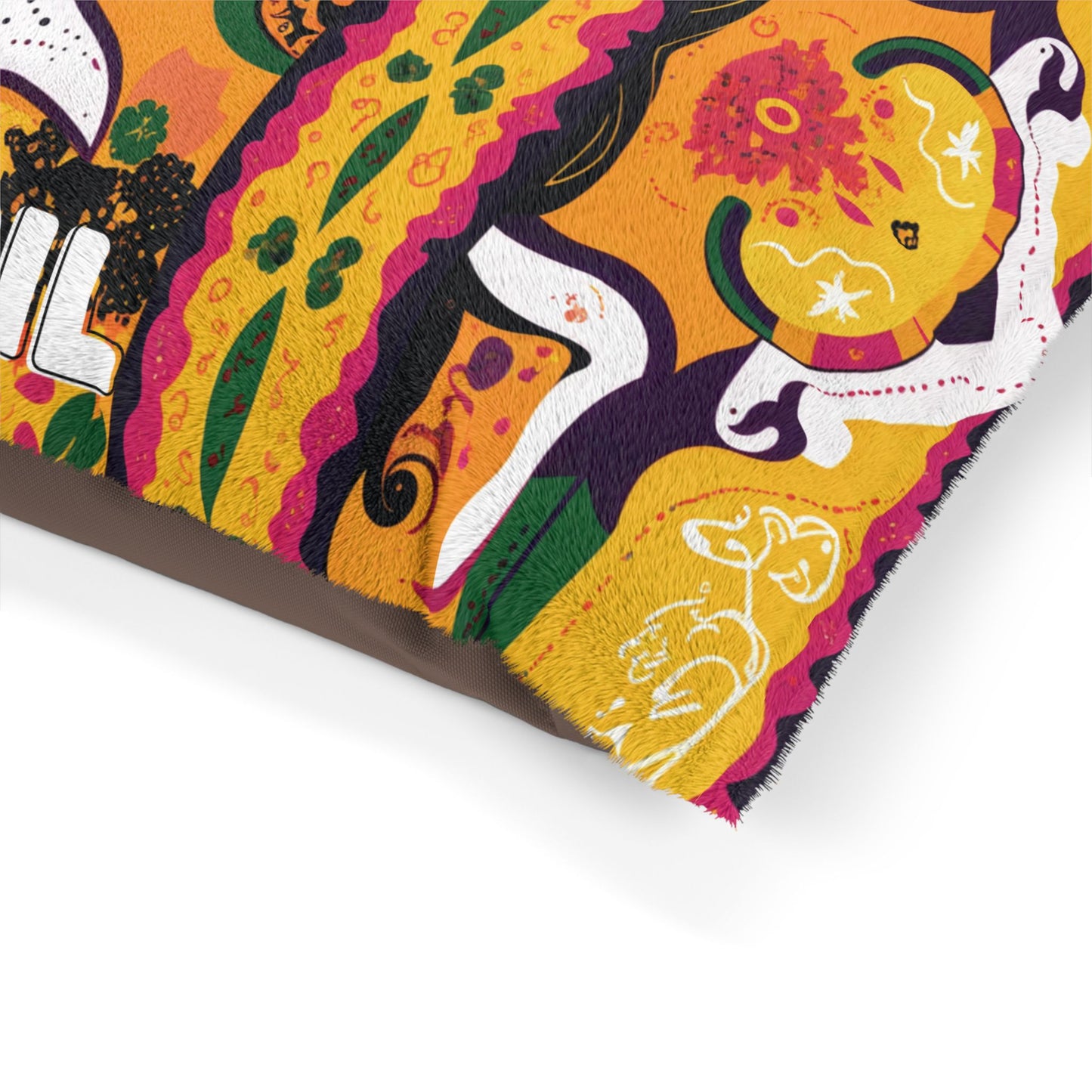 A colorful, African-inspired patterned fabric with abstract floral and animal motifs in orange, yellow, green, white, black, and magenta. The edge shows a brown underside, while whimsical animal shapes are outlined in white.