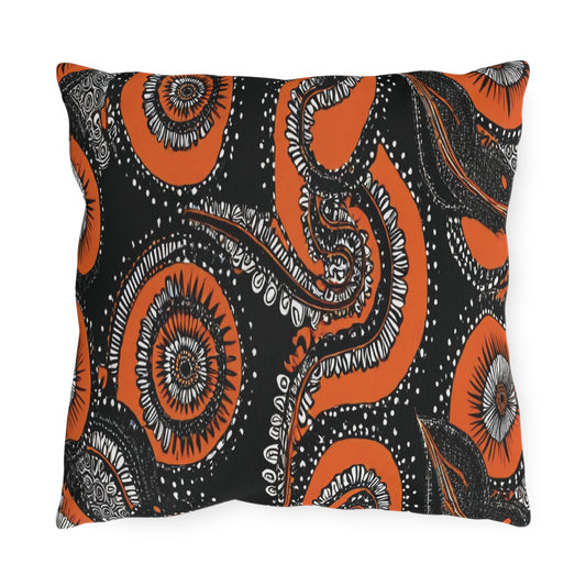 A rectangular pillow features an African-inspired abstract pattern of orange and black swirls, circles, and organic shapes with intricate white and black detailing, resembling a mix of floral and cosmic designs against a solid black background.