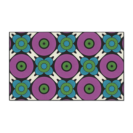 A rectangular non-slip rug with a repeating floral pattern. Large purple circles with dark centers are surrounded by smaller blue-green flowers on cream, separated by black lines, creating a bold, geometric, retro look perfect for African-inspired home decor.