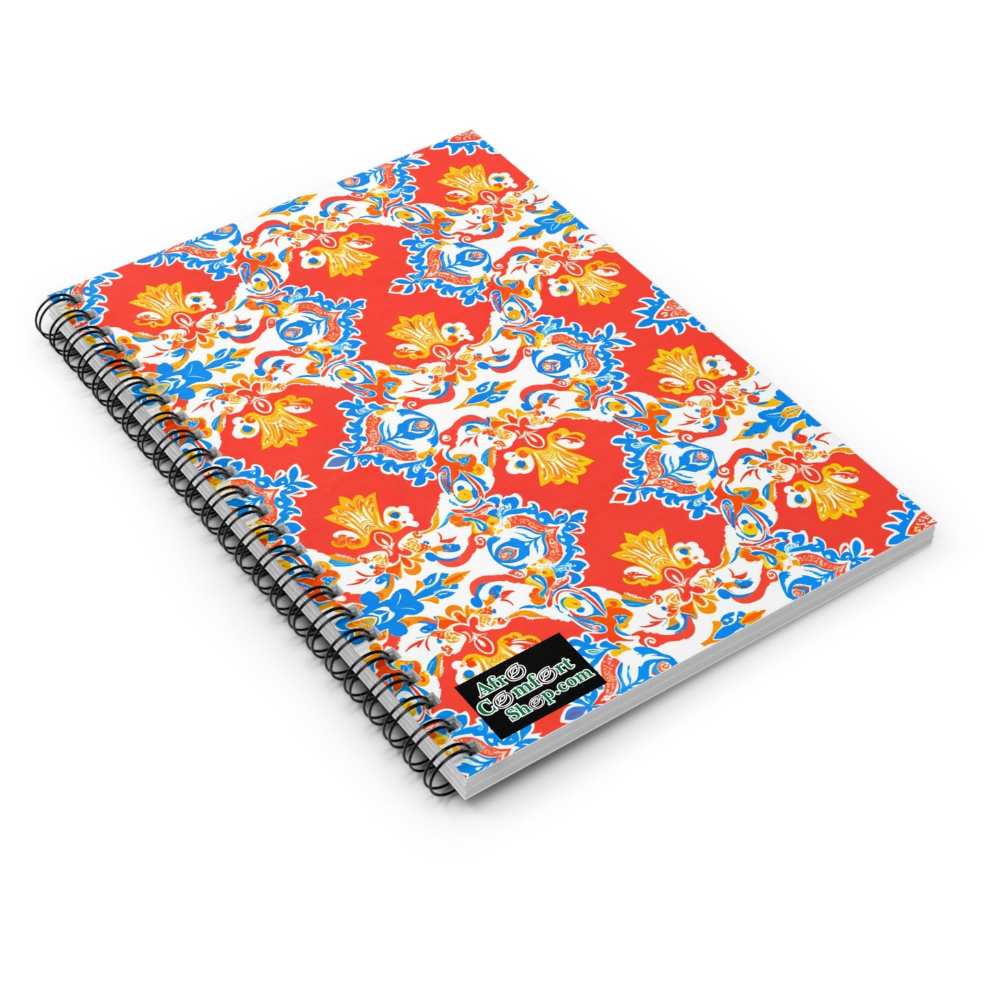 A spiral-bound, African-inspired notebook with a vibrant cover featuring ornate red, yellow, blue, and white floral patterns. A small black label with “Good Vibes Happen” sits in the lower right corner. Perfect for a premium writing experience.