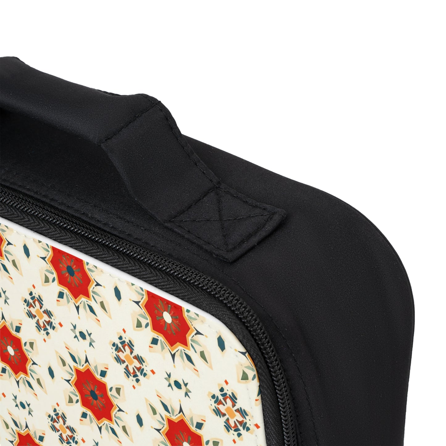 Close-up of an African-inspired lunch bag with a zipper and handle. The bag features a decorative panel with a cream background and red, orange, and teal geometric star-like shapes. The stitching on the handle is visible.