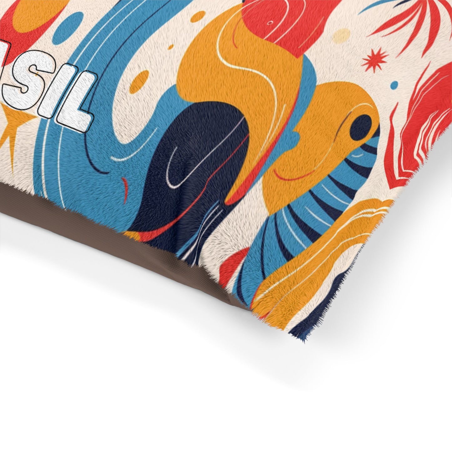 A close-up of a colorful, African-inspired fabric with playful abstract shapes in orange, blue, yellow, red, and white. The edge has a fuzzy texture, and part of the word “SIL” appears in bold letters among curved lines and organic motifs.