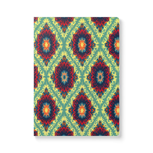 A rectangular African-inspired journal with a vibrant, repeating geometric floral pattern in red, orange, blue, and yellow on a green background, forming diamond shapes throughout. Perfect for creative journaling, the book is viewed from a slightly angled front perspective.