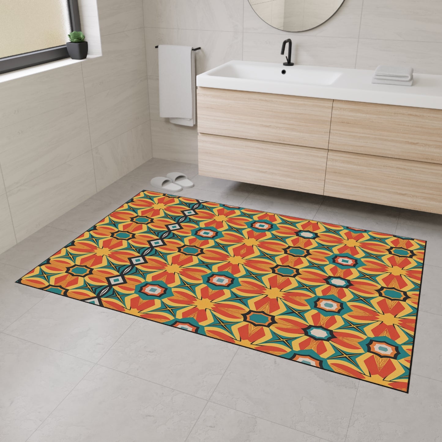 A modern bathroom with light beige tile, a floating wood vanity, round mirror, towel rail, and slippers. The floor features an African-inspired, custom floor mat—non-slip with a bold geometric floral pattern in orange, yellow, red, teal, and black.