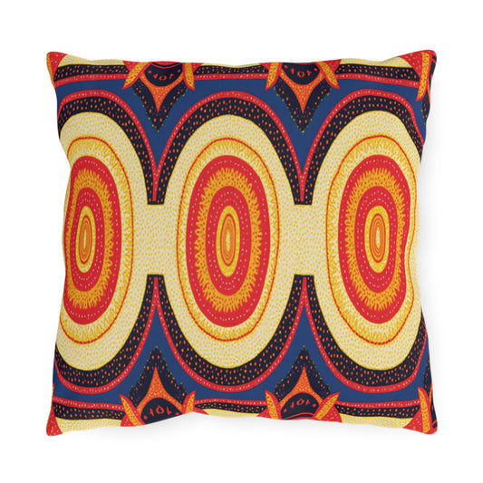 A square pillow with a bold, African-inspired geometric pattern of repeating oval shapes in yellow, orange, and red, outlined in black. The dark blue background features small dotted details and vibrant orange star-like accents at the curves of the ovals.