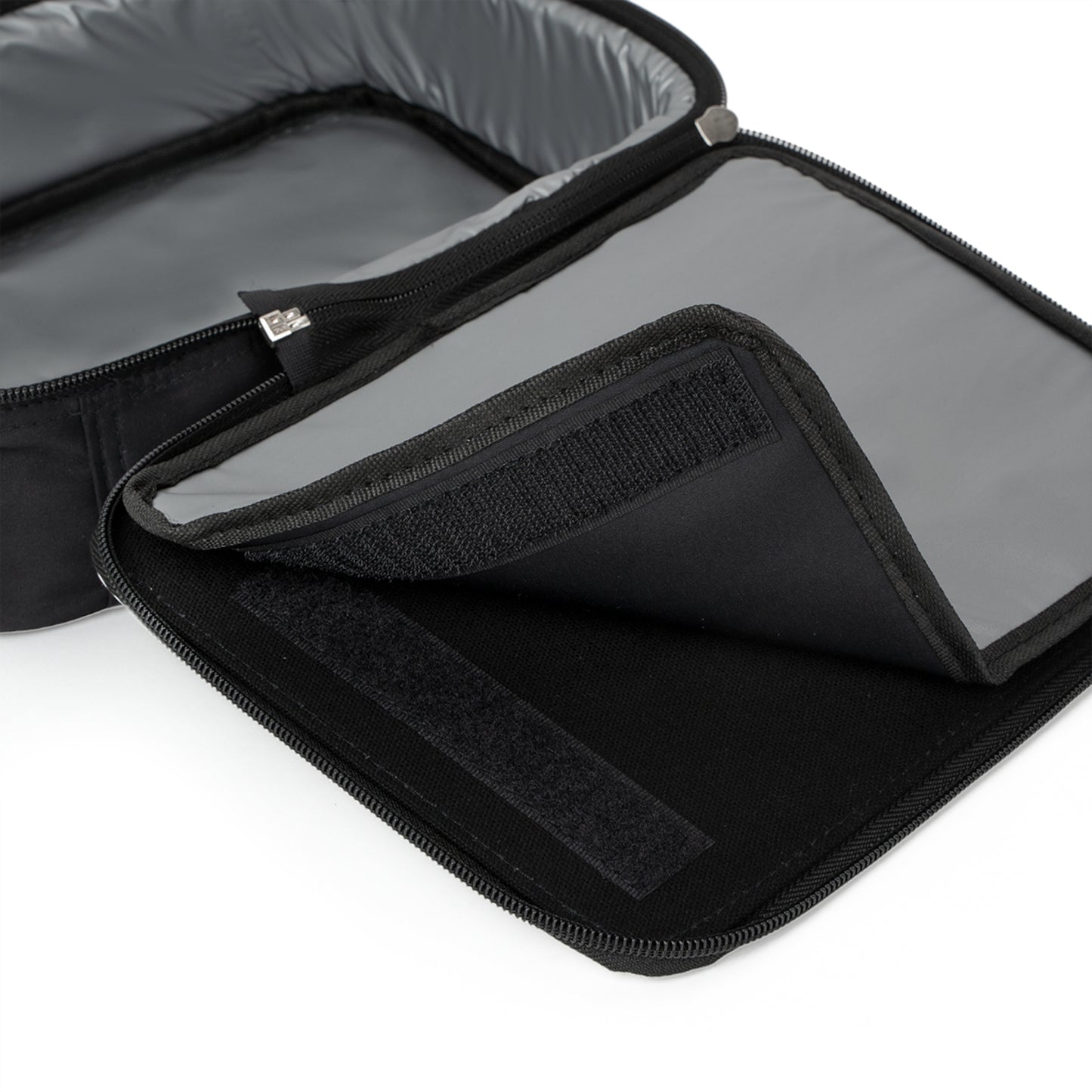 Close-up of an open black insulated lunch bag with a grey interior. This versatile African-inspired lunch tote features a zipper closure and Velcro flap, revealing two compartments that keep your food items separated and secure.