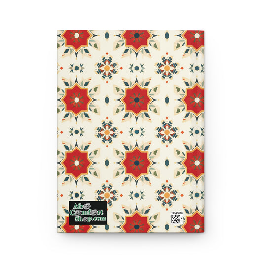 A hardcover journal with a cream background features a repeating geometric floral pattern in red, green, and orange. A green and black “AfroComiArtShop.com” label accents this African-inspired notebook, with a small QR code at the bottom right.