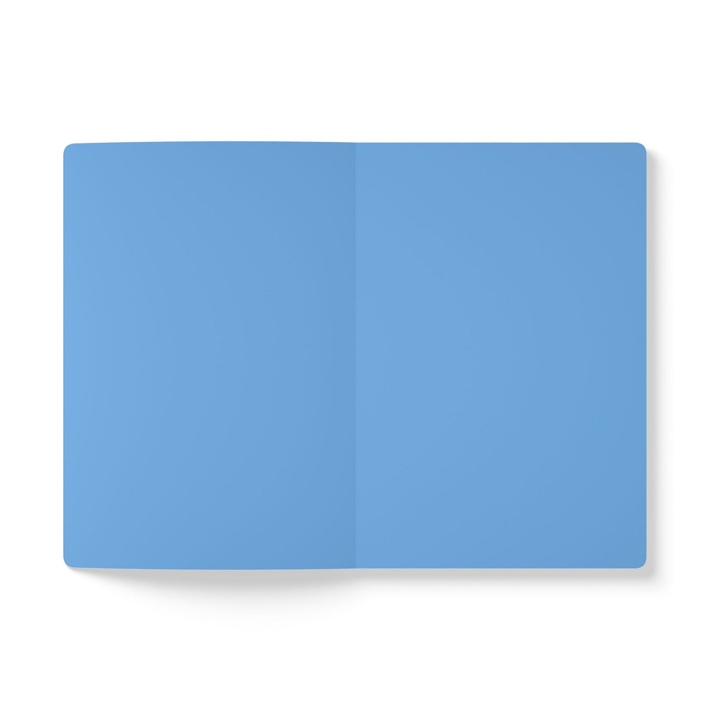 A top-down view of an open creative journal with blank, light blue pages. The journal lies flat on a white background, featuring a visible vertical crease in the center where the pages meet. No text, lines, or images appear on the pages.
