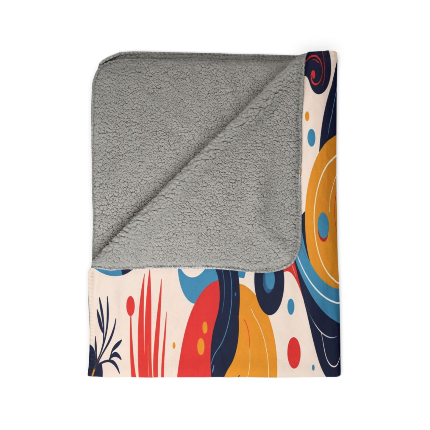 A folded sherpa fleece blanket with a soft, textured light gray inner lining. The outer side features a colorful, abstract design with shapes in red, yellow, orange, blue, and black on a white background, displayed on a white surface.