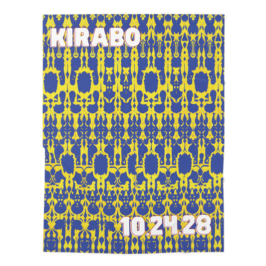 A bold patterned fabric or poster, perfect as an African-inspired decor piece or personalized baby blanket, features a vibrant blue and yellow symmetrical design. At the top left, “KIRABO” appears in white and pink; the bottom right shows “10.24.28.”.