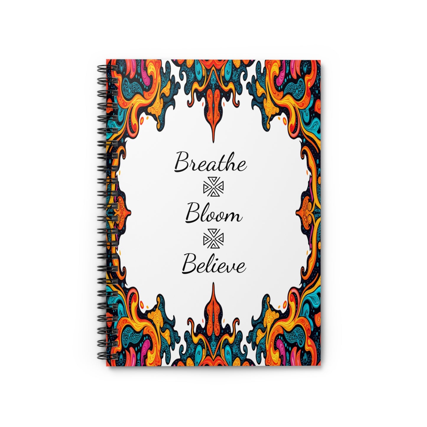 A spiral notebook with an ornate, colorful border featuring culturally inspired designs in red, yellow, orange, teal, and blue. The white center displays cursive black text—“Breathe,” “Bloom,” and “Believe”—each separated by a decorative symbol.