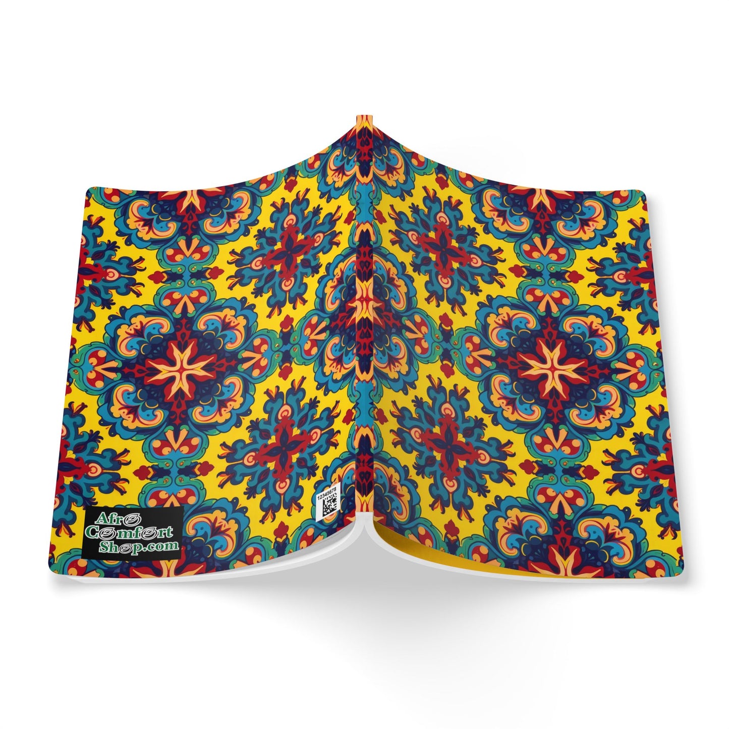 An open African-inspired journal displays a vibrant cover with a symmetrical, floral-inspired geometric pattern in red, blue, green, and orange on yellow. The bold design evokes traditional motifs—perfect for daily journaling or as a creative journal.