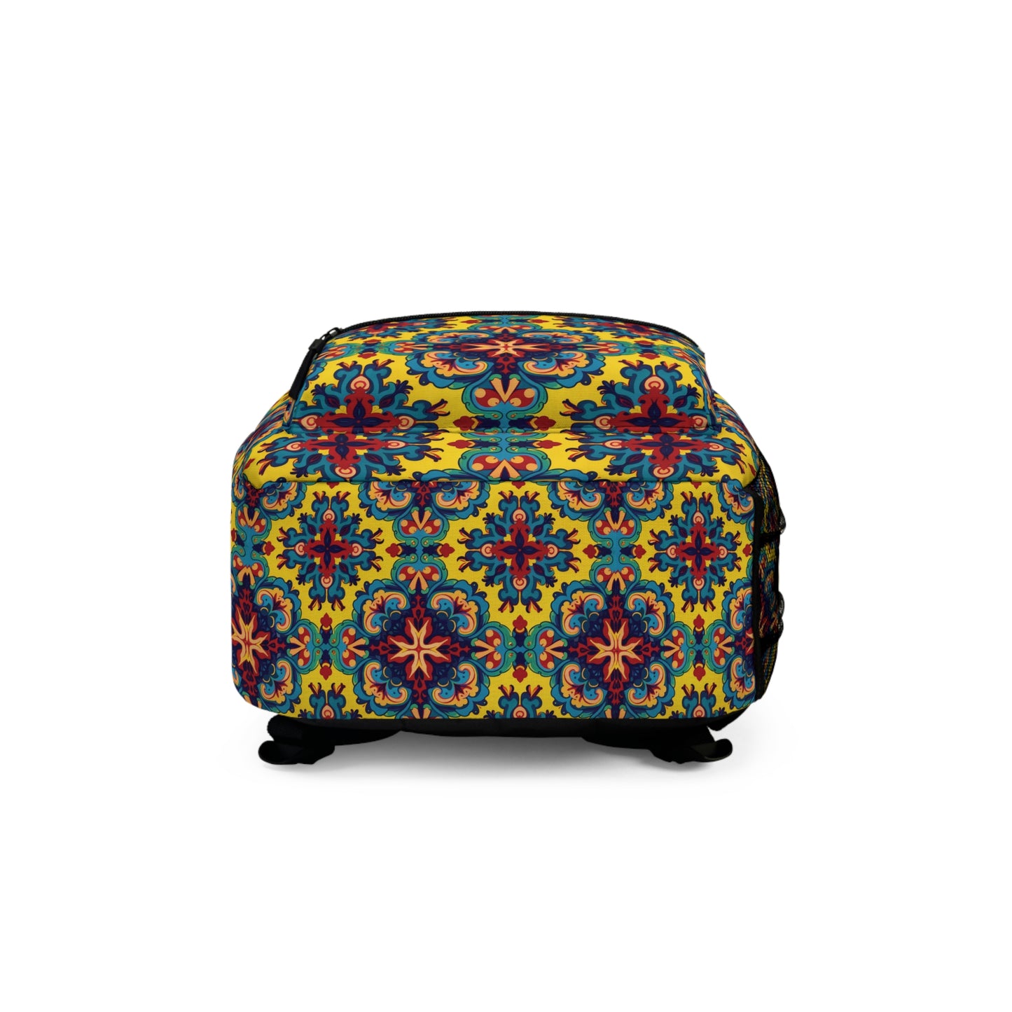 A rectangular ottoman with a vibrant, colorful pattern reminiscent of a boho chic rucksack, featuring symmetrical floral and geometric motifs in blue, red, and orange on a yellow background. The ottoman has short black legs and a smooth upholstered surface.