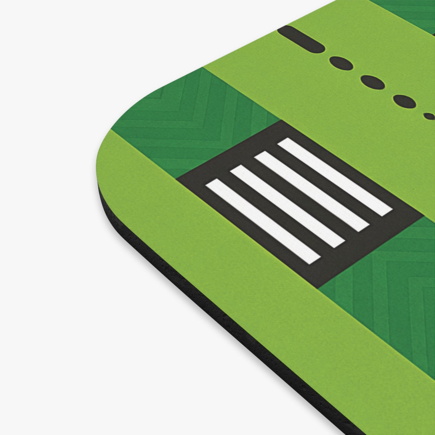 A close-up of a vibrant desk accessory, this non-slip mouse pad features a geometric design in various shades of green. The surface has black and white rectangular and dot patterns, resembling electronic buttons or controls.