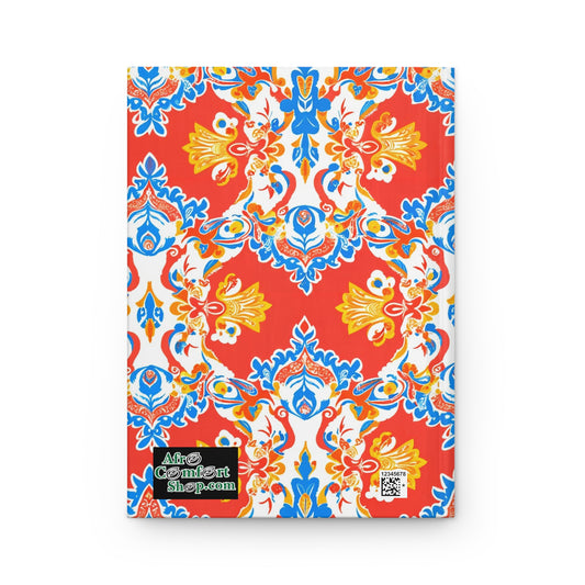 A durable writing journal with a vibrant red cover featuring an ornate, symmetrical floral pattern in blue, yellow, and white. The AfroComicArt shop.com logo and QR code accent this culturally-rich notebook’s African-inspired design.