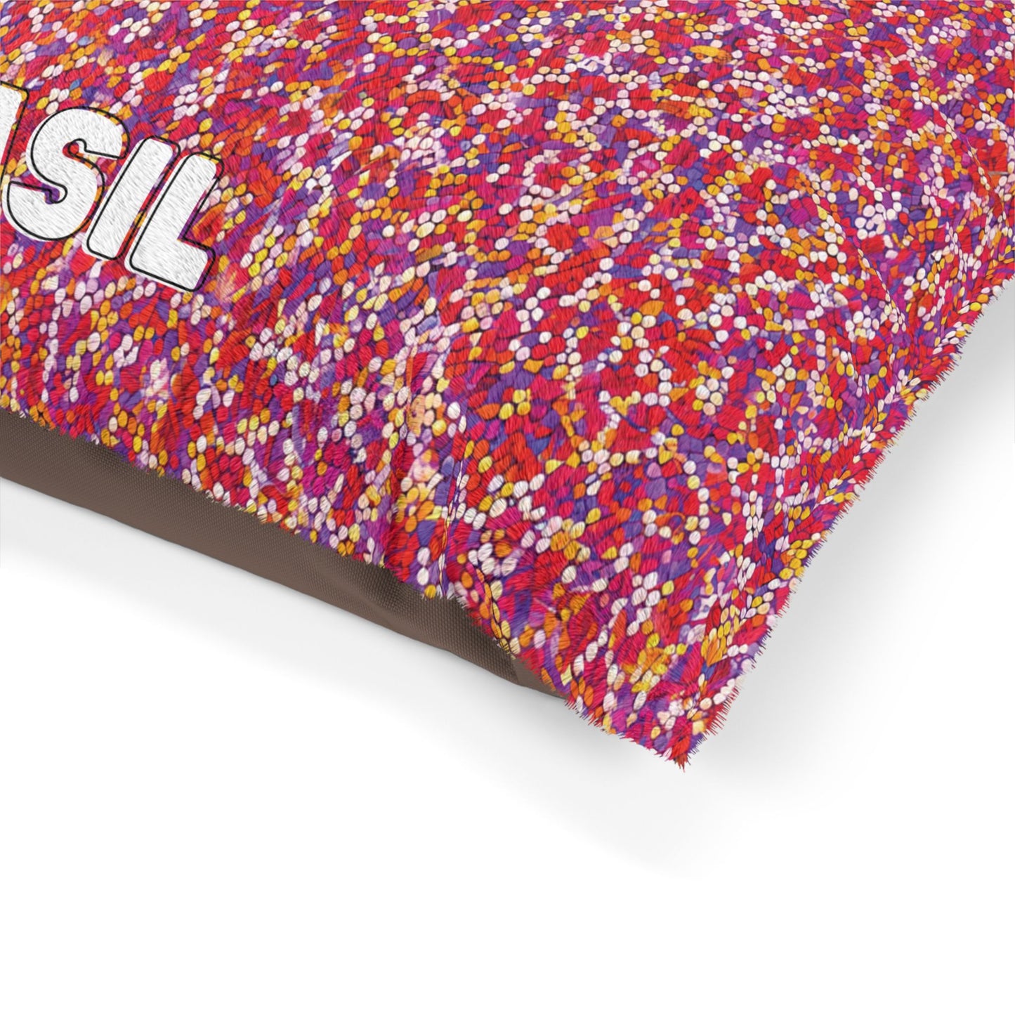 A colorful cushion with a densely packed pattern of small red, pink, orange, and white dots. Part of the word SIL in large, white, embroidered letters is visible in the top left corner. Durable construction ensures lasting appeal on a white background.