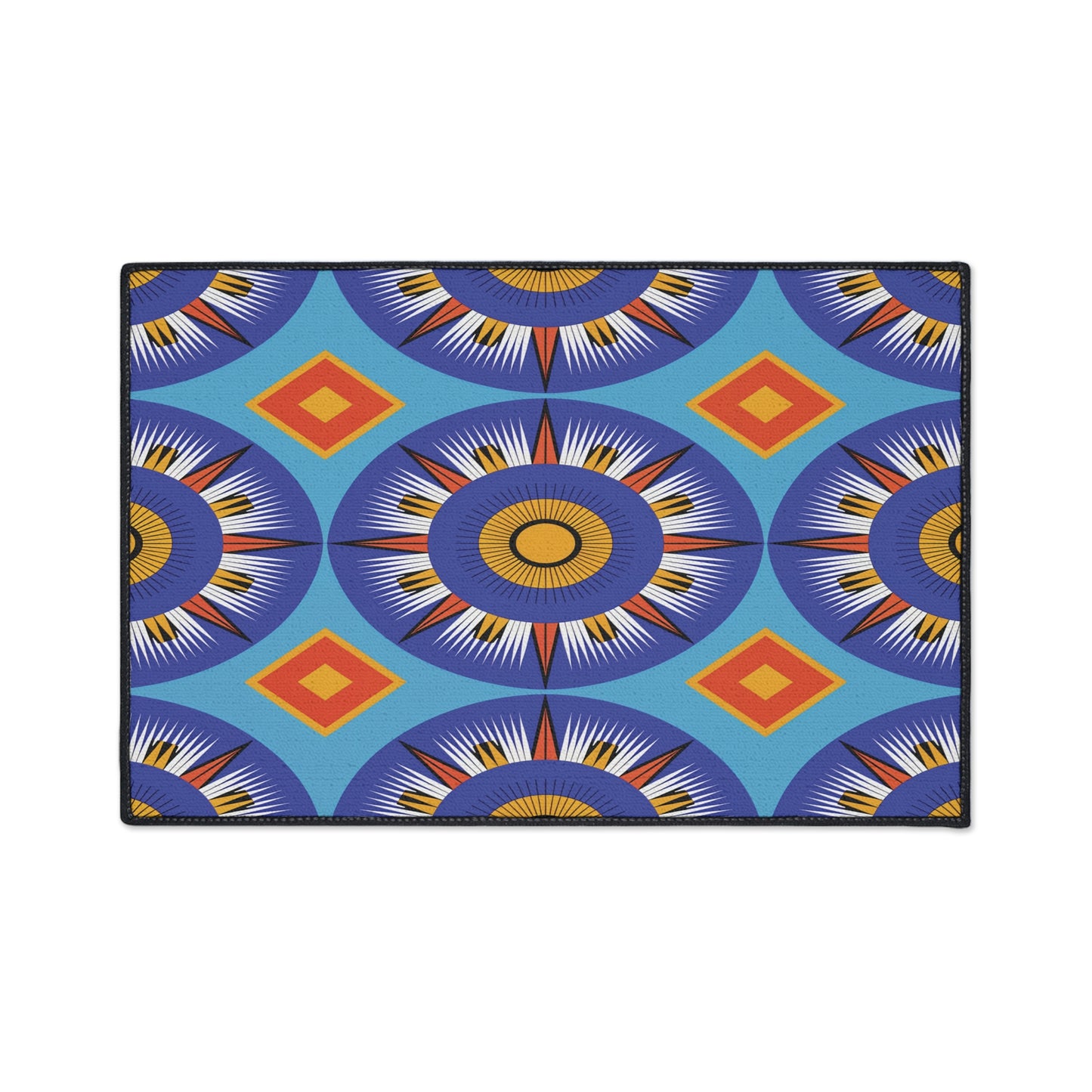 Rectangular mat featuring an African-inspired geometric pattern with blue, purple, yellow, and white sunbursts plus orange diamonds on a light blue background. The vibrant design is eye-catching and includes a non-slip rubber backing for added safety.