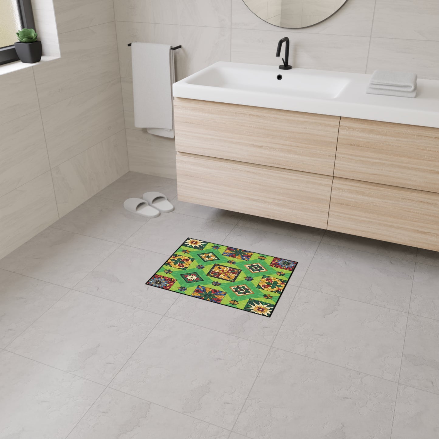 A modern bathroom with light wood cabinetry, white sink, and black faucet. A colorful, geometric patterned green mat with non-slip rubber backing is on the gray tiled floor. The space is bright, minimalistic, and features African-inspired aesthetics.