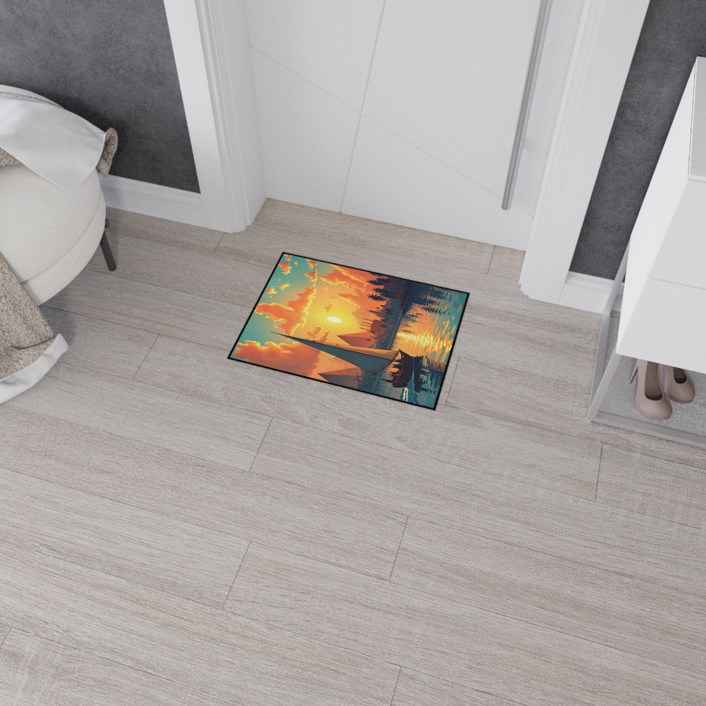 A colorful rectangular doormat with a scenic sunset, mountains, trees, and a canoe on a lake features non-slip rubber backing. Placed in a modern entryway with light wood floors, it adds charm beside a white cabinet and round chair.