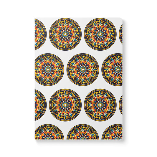 A white notebook cover features a repeating pattern of circular, colorful mandalas with intricate orange, blue, yellow, and black geometric designs—an African-inspired journal perfect for daily journaling.