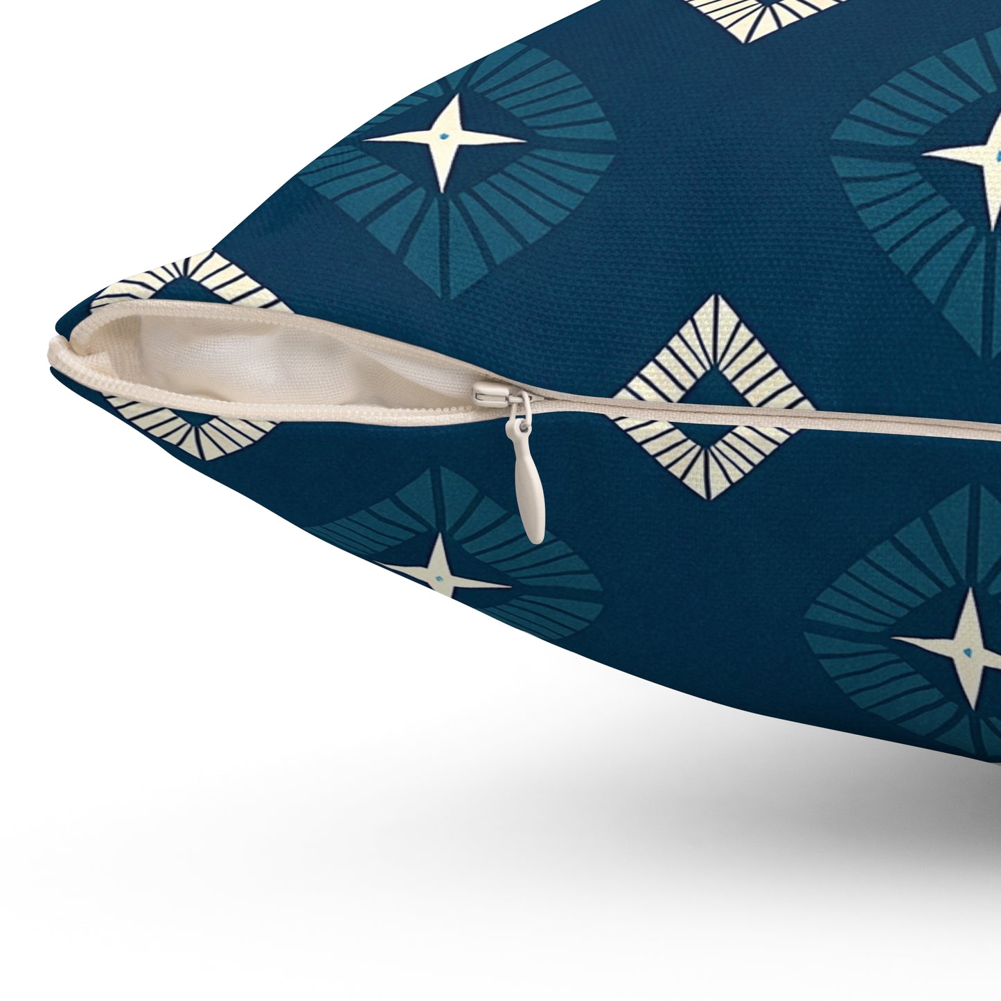 Close-up of an African-inspired pillow with a navy blue cover featuring vibrant geometric diamond shapes and star motifs in light blue and cream. The partially opened zipper reveals the off-white interior lining, perfect for stylish home decor.