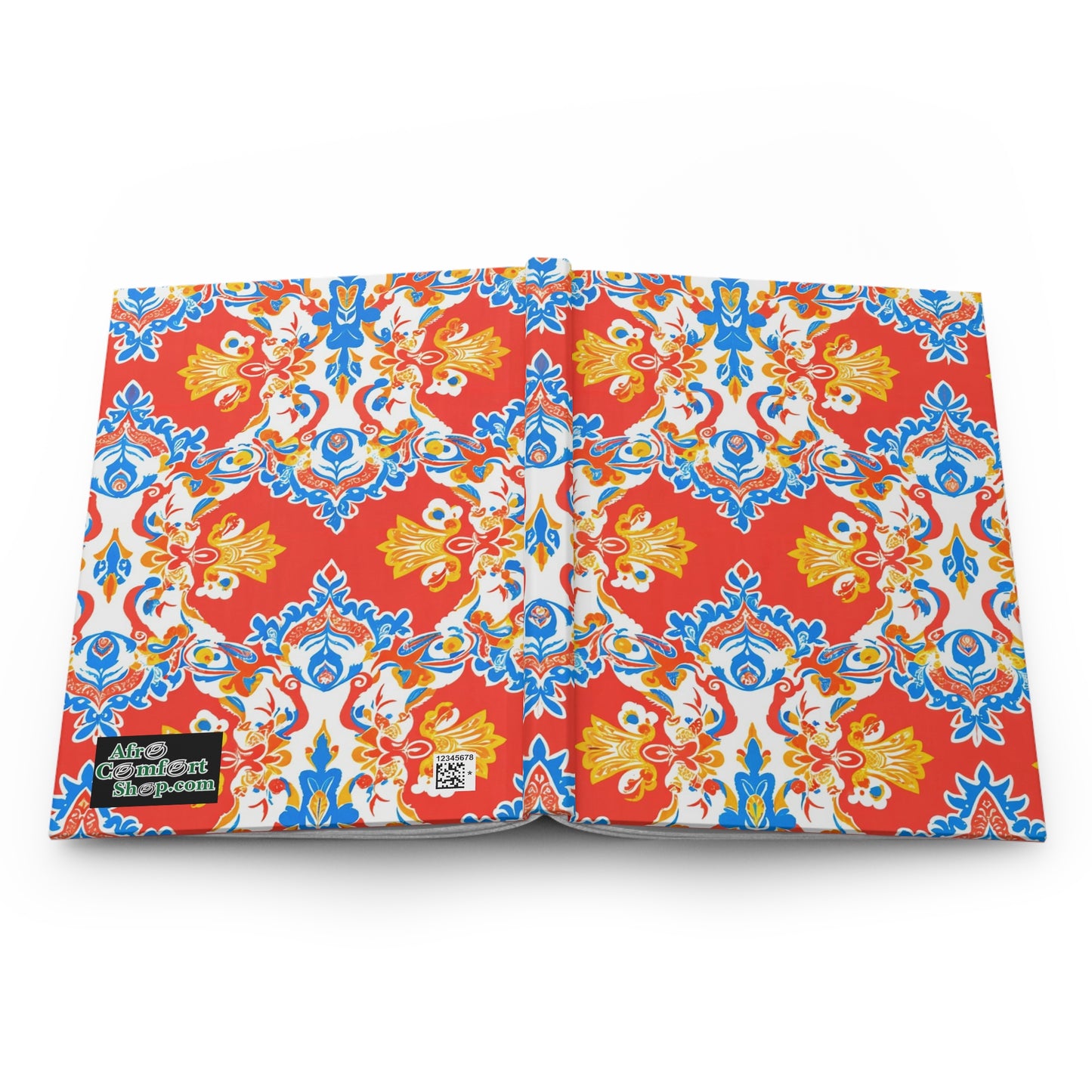 An open African-inspired journal with a bright, intricate pattern of red, yellow, blue, and white floral and geometric designs. The hardcover journal has a black label with white and green text and a small QR code in the bottom left corner on a white background.
