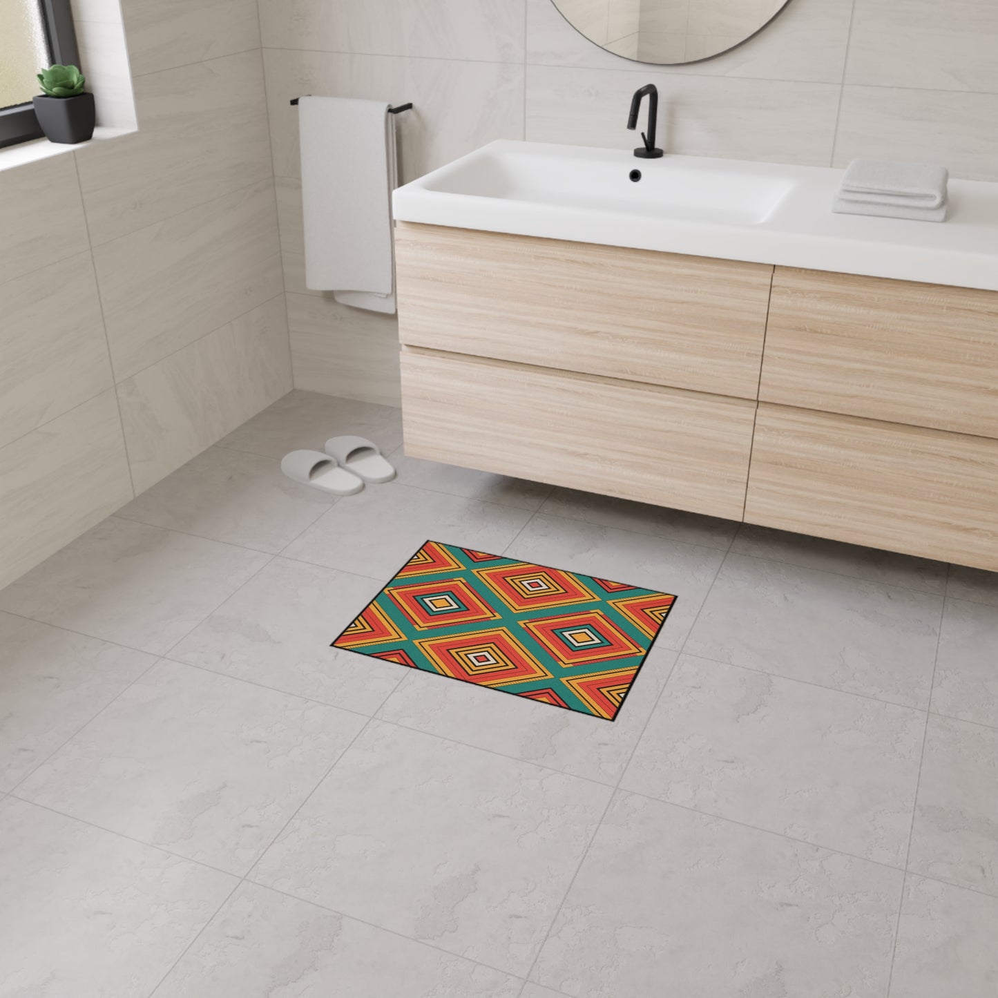 Modern bathroom with light wood cabinets, white sink, and round mirror. A colorful geometric-patterned mat with African-inspired home decor style and non-slip rubber backing brightens the light gray tiled floor. White slippers and a folded towel are visible.