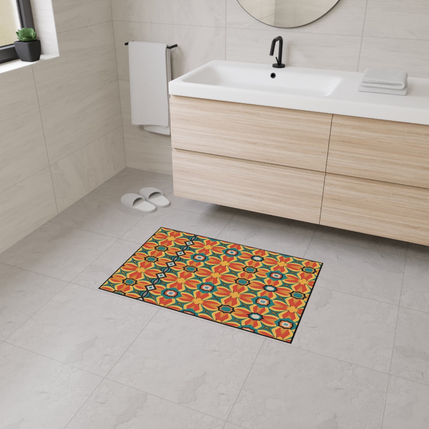 A modern bathroom with light beige tiles, a wooden floating vanity, white sink, and black faucet. The colorful rug with a bold floral geometric pattern features a non-slip rubber backing for safety. White slippers sit near the towel rack.