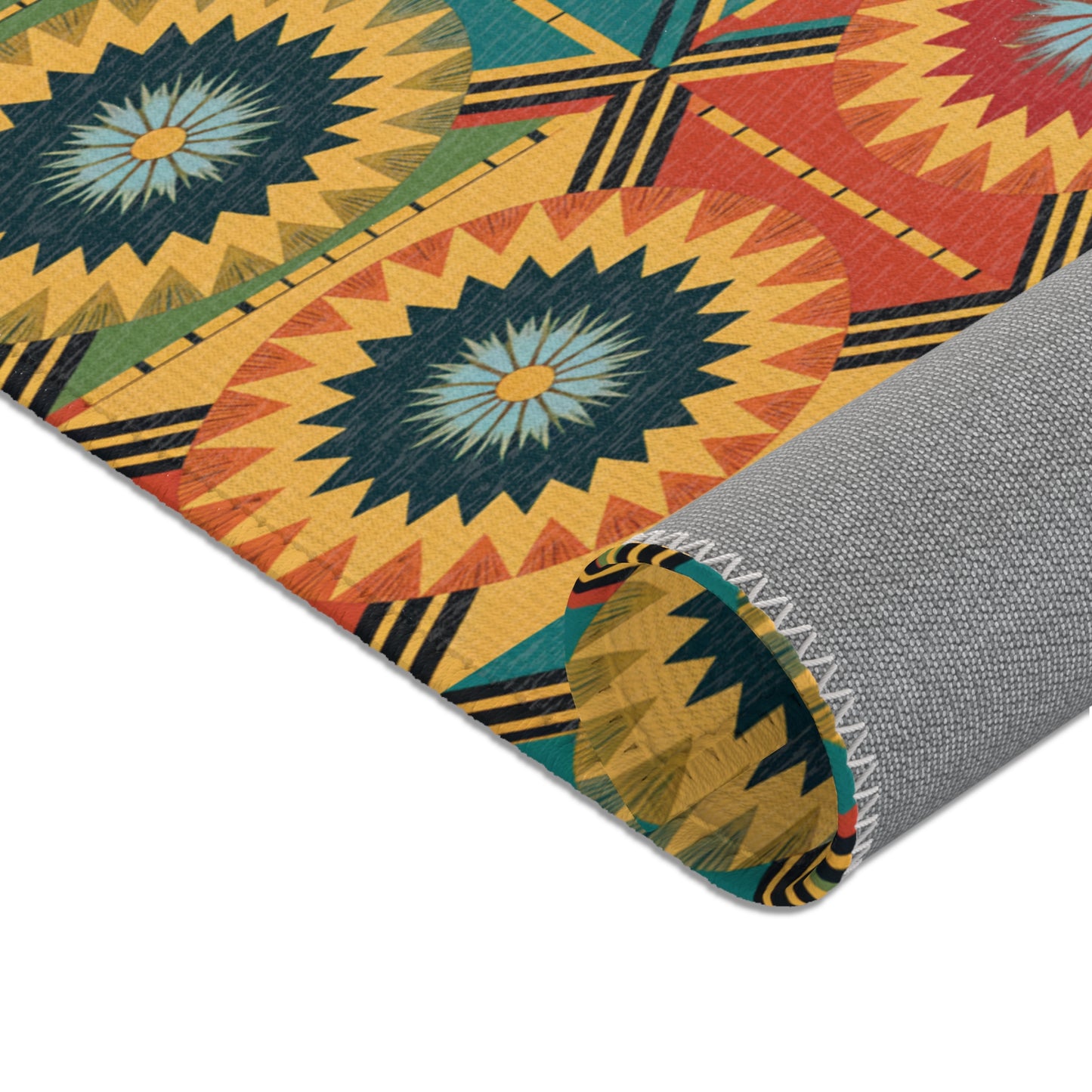 A colorful fabric roll displays a bold geometric pattern inspired by African design rugs, featuring circular starburst motifs in yellow, blue, and orange. The edge is stitched with white thread, while the durable polyester chenille underside is solid gray.