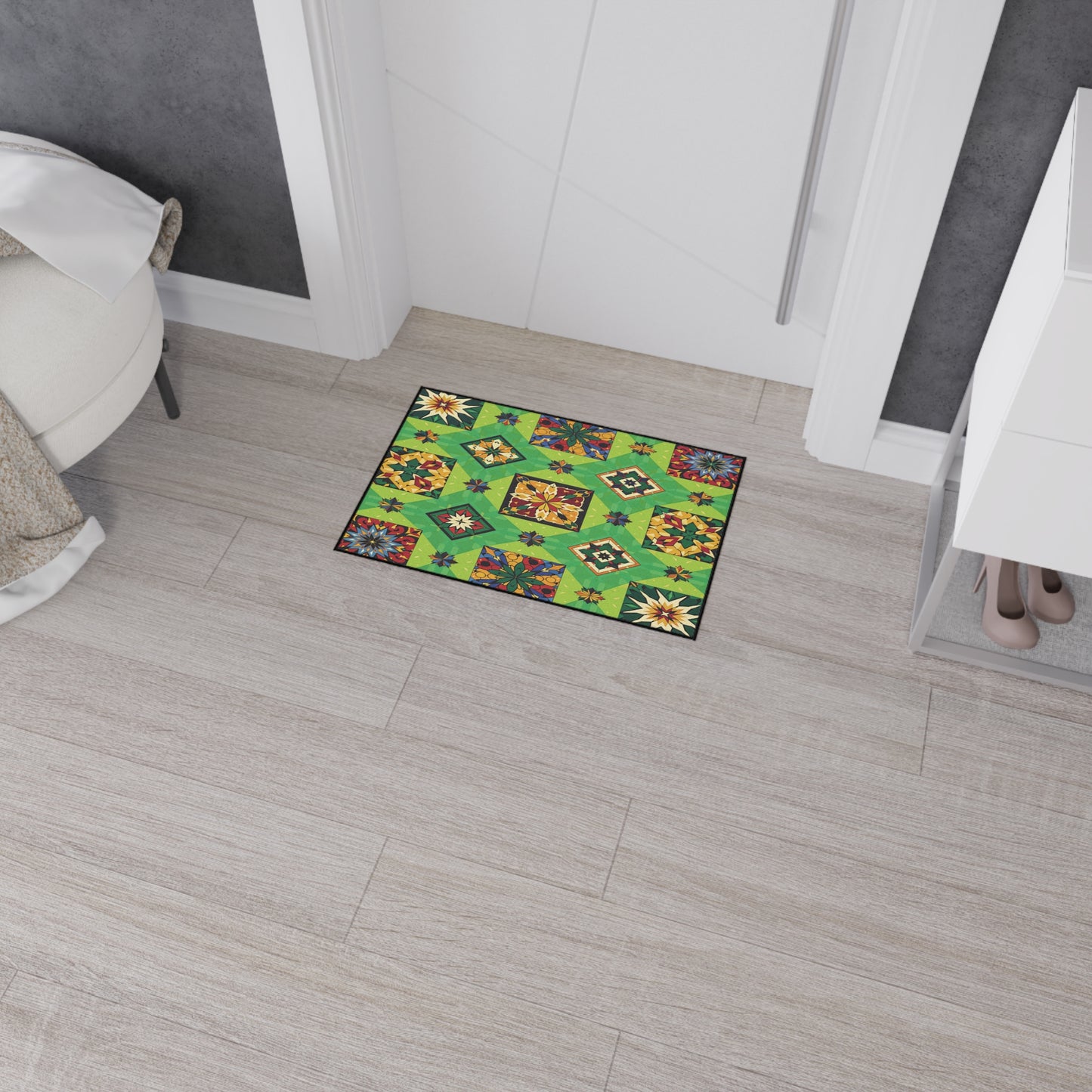 A small rectangular rug with a bright green background and African-inspired geometric and floral patterns lies on light wood floor tiles near a white bedroom door. A shoe cabinet with beige high heels and a white bed are partially visible.