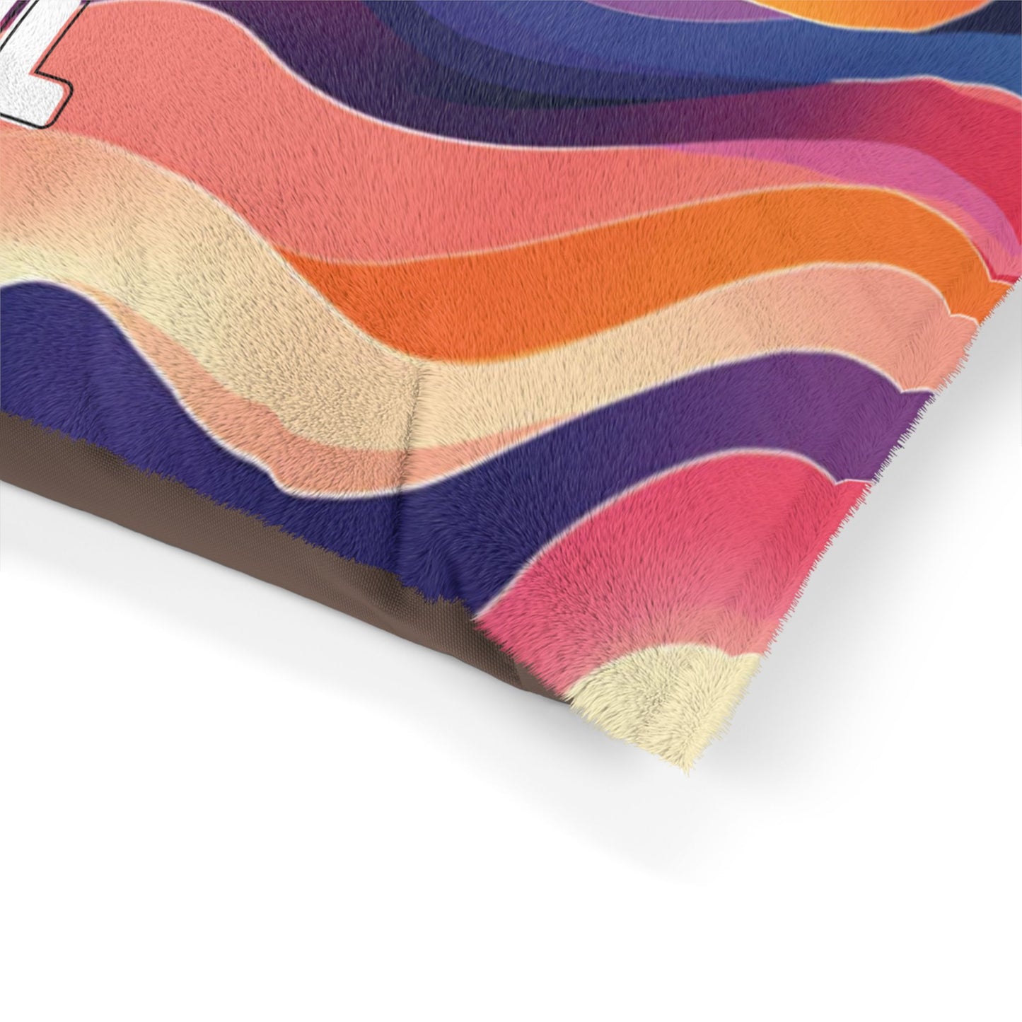 A close-up of a fuzzy blanket corner with African-inspired, colorful wavy stripes in pink, orange, purple, cream, and blue. The soft, plush texture stands out, with part of a white number 4 visible in the upper left on a plain white background.