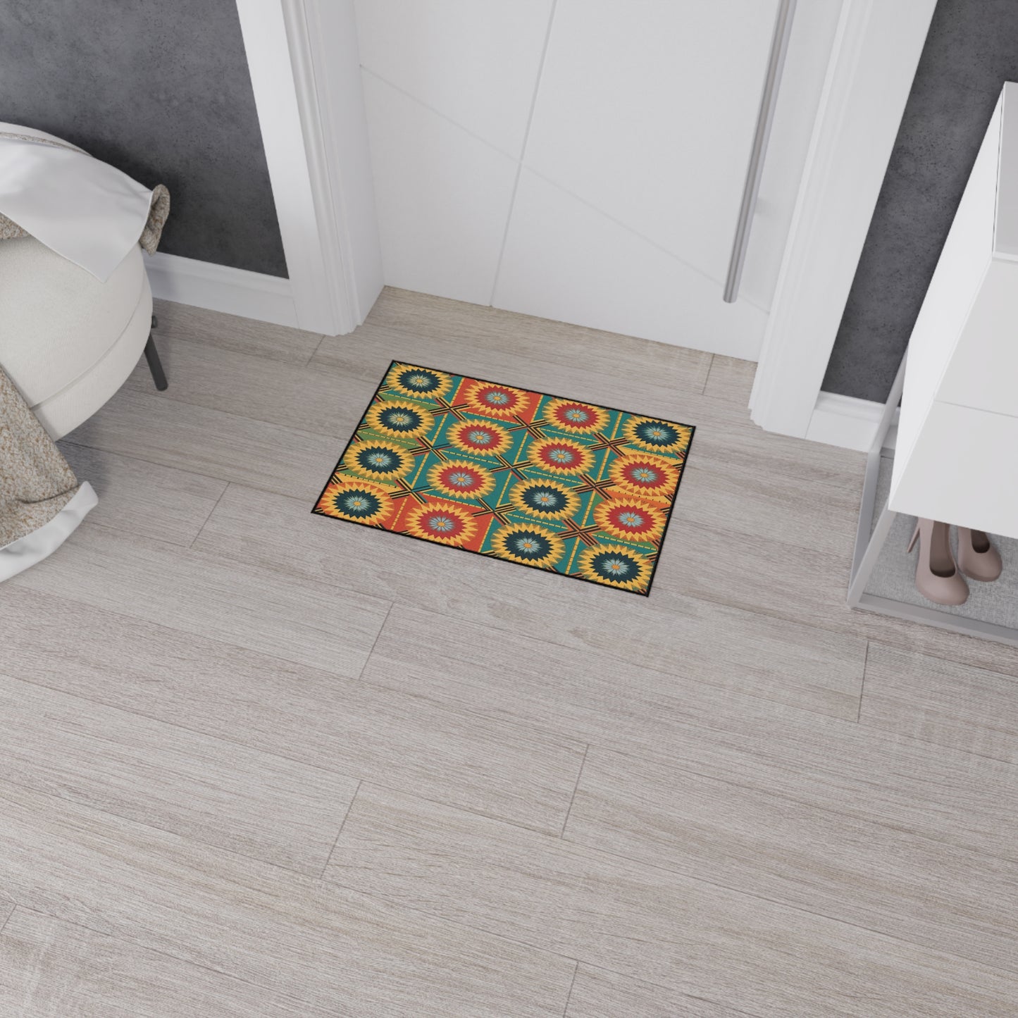 A small rectangular mat with African-inspired aesthetics and a colorful geometric pattern featuring red, yellow, green, and blue circles and starbursts lies on a light wood floor in a modern hallway near a white bench and shoe storage.