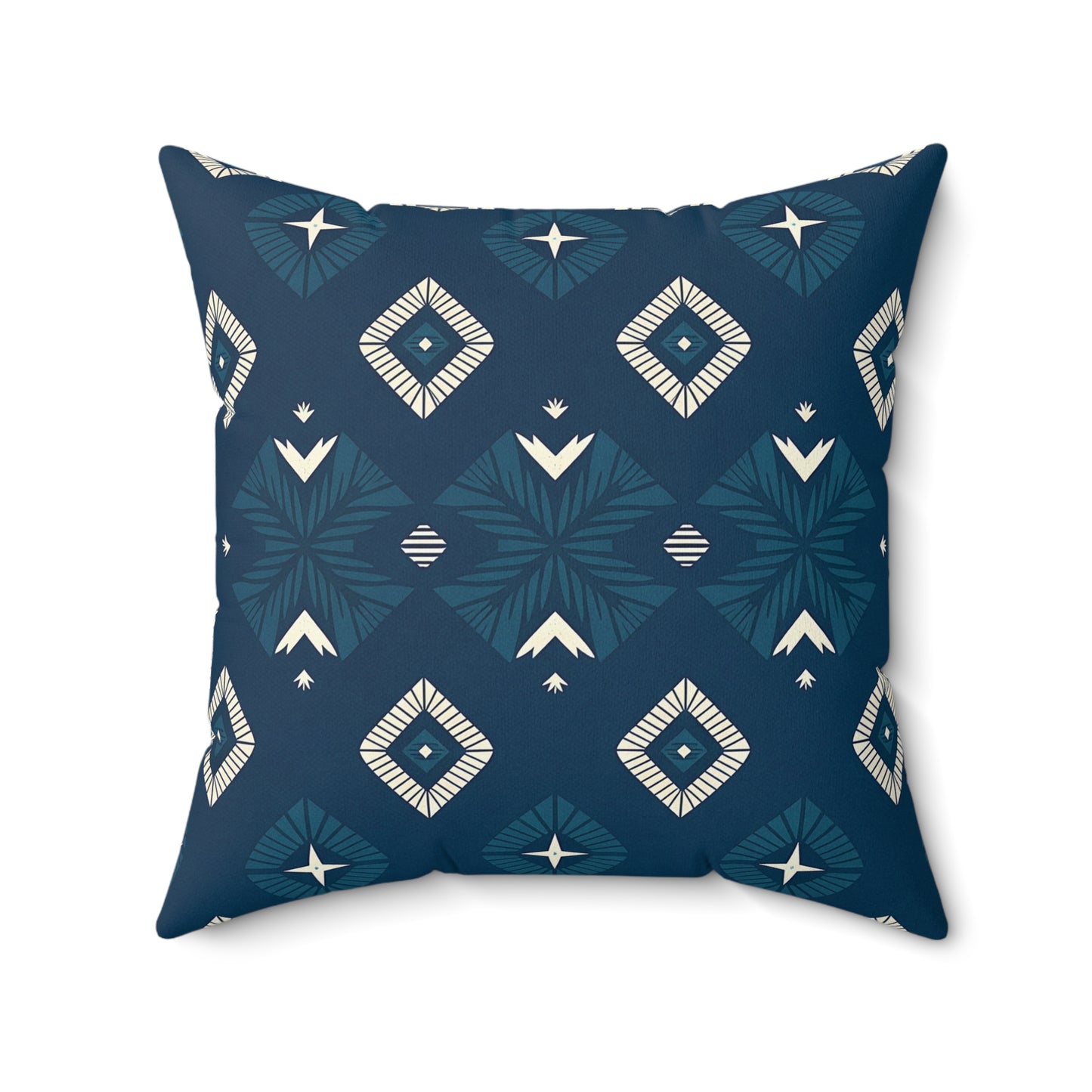 A square decorative pillow with a dark blue background features a geometric pattern of white and teal diamonds, stylized star shapes, and chevrons in a symmetrical design. This vibrant pillow adds bold style to any home decor with its smooth texture and slightly rounded corners.
