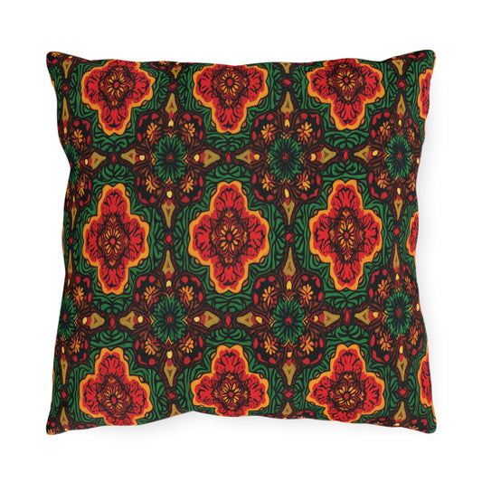 A square pillow with an intricate, African-inspired floral and geometric pattern in red, orange, green, and yellow. The symmetrical design features stylized flowers and leaves in a repeating, kaleidoscopic motif on a dark background.