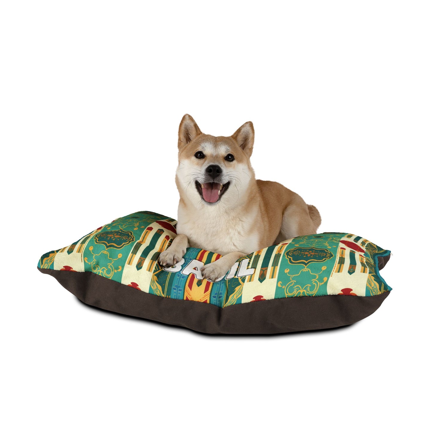 A happy Shiba Inu dog lies on a rectangular pillow with a colorful pattern of green, yellow, and black piano keys and red accents, offering luxurious comfort against a plain white background. The dog looks forward, mouth open in a cheerful smile.