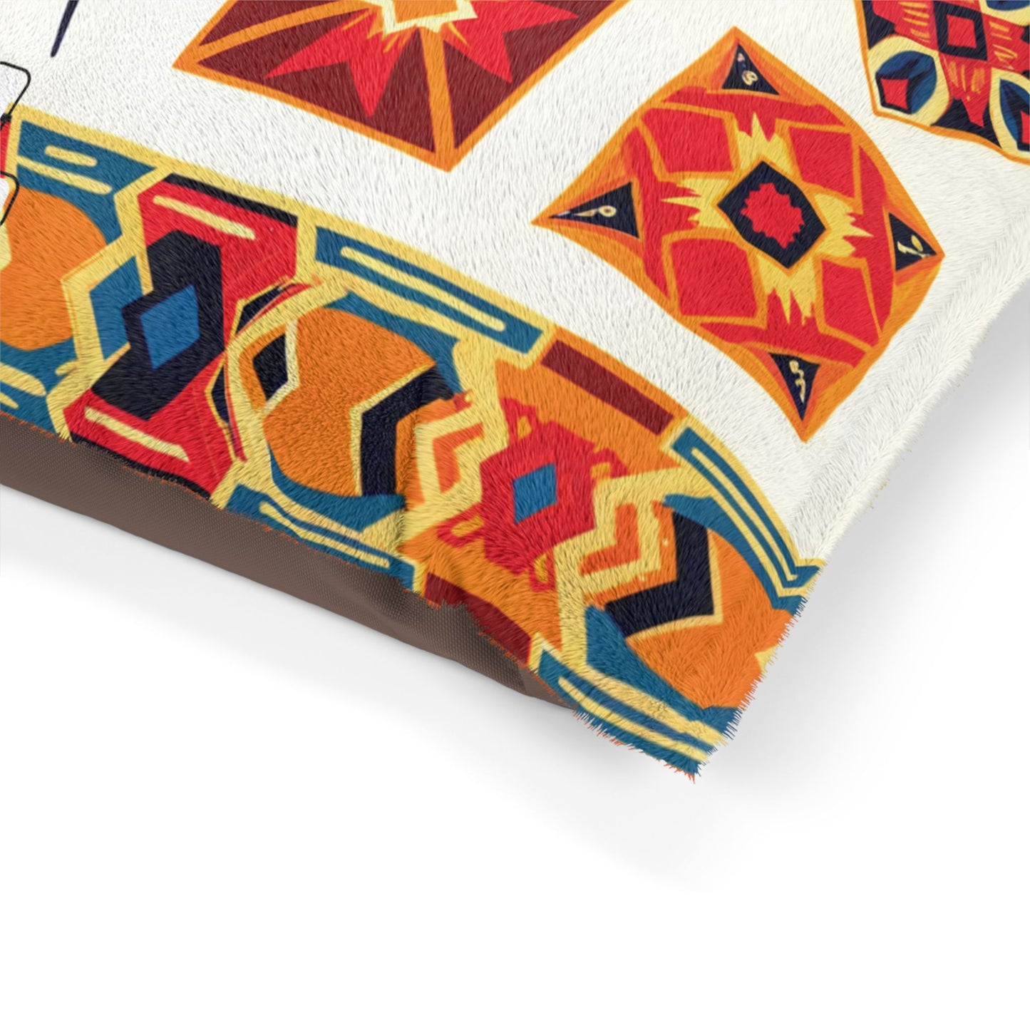 A close-up of a cushion with a colorful geometric pattern in red, orange, yellow, and blue tones on white fabric. The diamond and star shapes create a vibrant, southwestern or African-inspired look. The cushion is set against a white background.