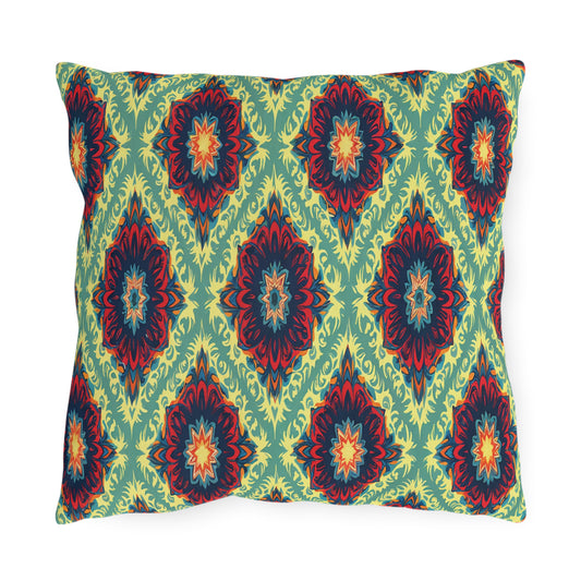 A square pillow featuring a bold, symmetrical African-inspired pattern of red, blue, and orange floral starbursts on a light green background with intricate yellow-green accents, creating a vibrant, decorative look.
