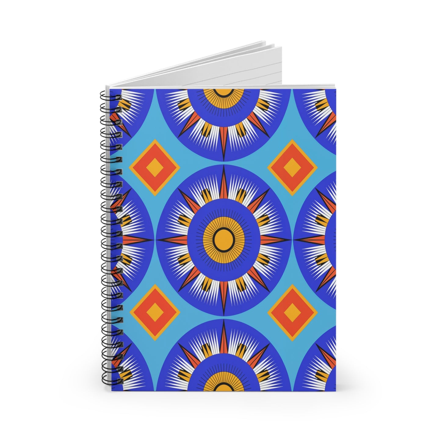 A spiral-bound notebook with a vibrant cover design featuring culturally inspired mandala-like patterns and orange-red diamond shapes on a blue background. The notebook stands upright, offering a premium writing experience with its slightly open pages.