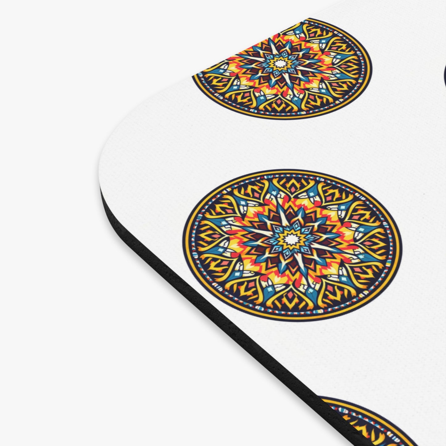 A white surface features colorful, African-inspired mandala designs with intricate geometric patterns in yellow, orange, red, blue, and black. This vibrant desk accessory has evenly spaced mandalas and a rounded edge with a thin black border.