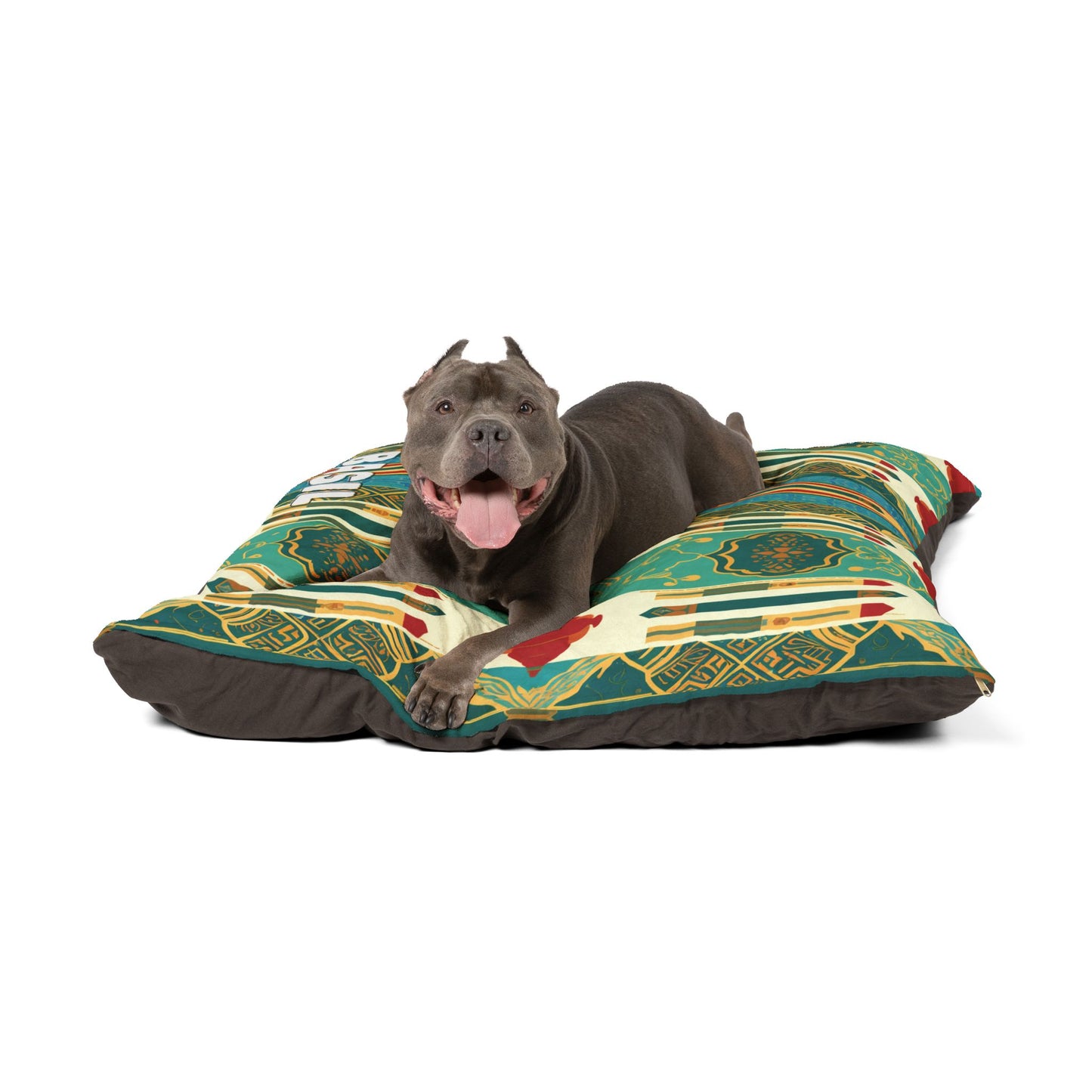 A happy gray pit bull with cropped ears and a pink tongue lolls out, lying on a large, colorful patterned dog bed featuring durable construction and luxurious comfort, with green, yellow, red, and white designs against a white background.
