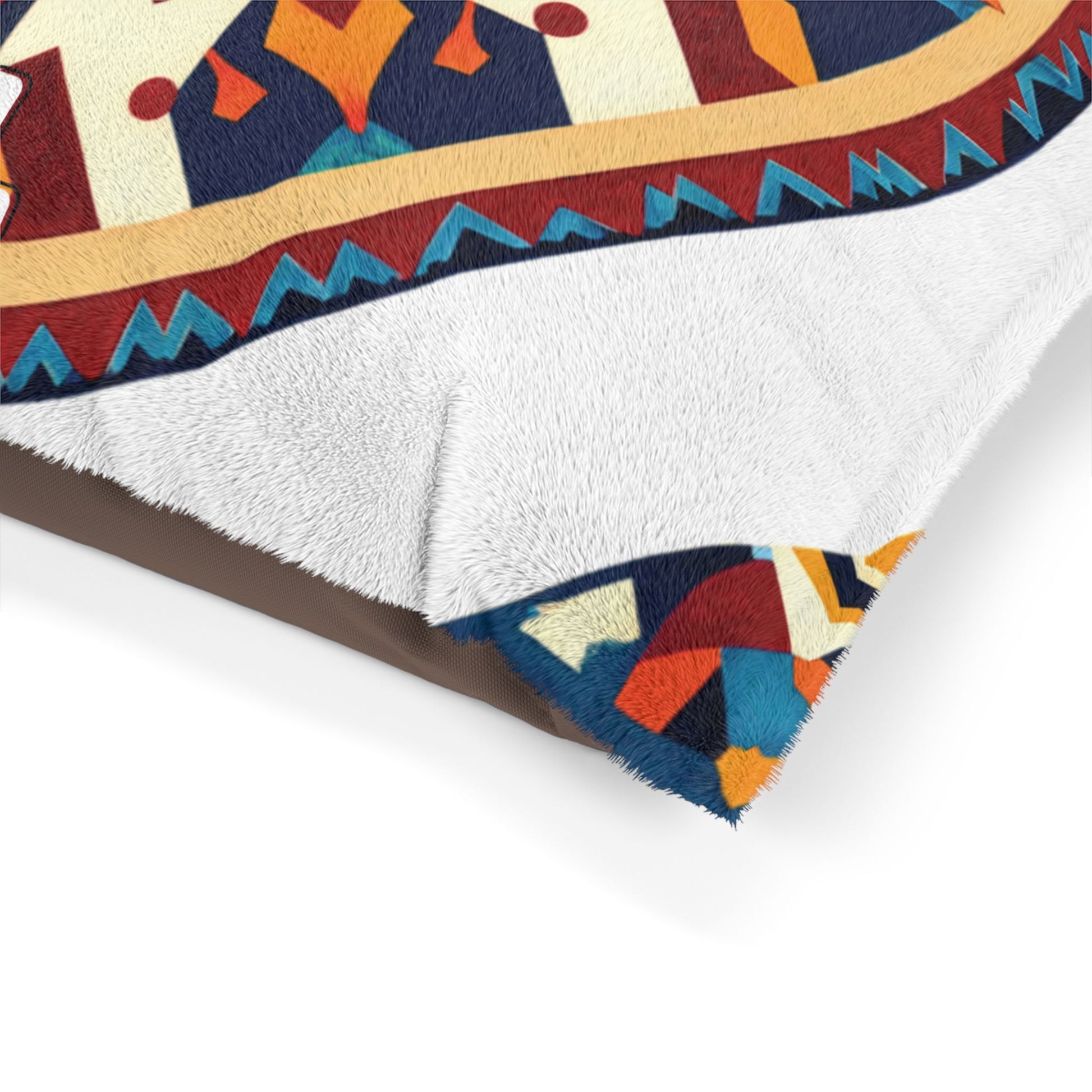A soft, white, fuzzy blanket is folded to reveal a vibrant, geometric pattern underneath. The durable construction ensures lasting use while offering luxurious comfort with bold red, orange, blue, yellow, and teal designs and a decorative border.